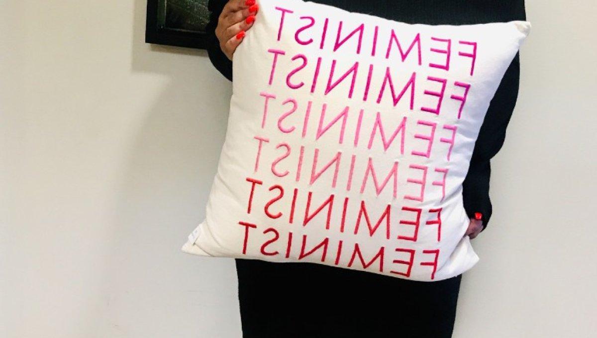 Woman holding feminist pillow