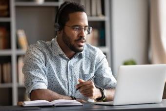 Focused businessman wear headphones study online watching we